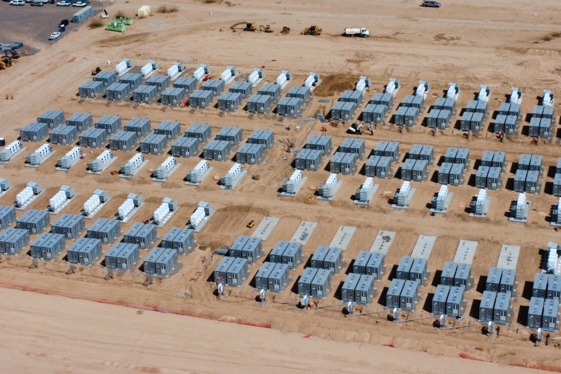 A modern electrical substation under a clear blue sky, with multiple transformers and high-voltage equipment, showcasing the infrastructure for electrical power distribution.